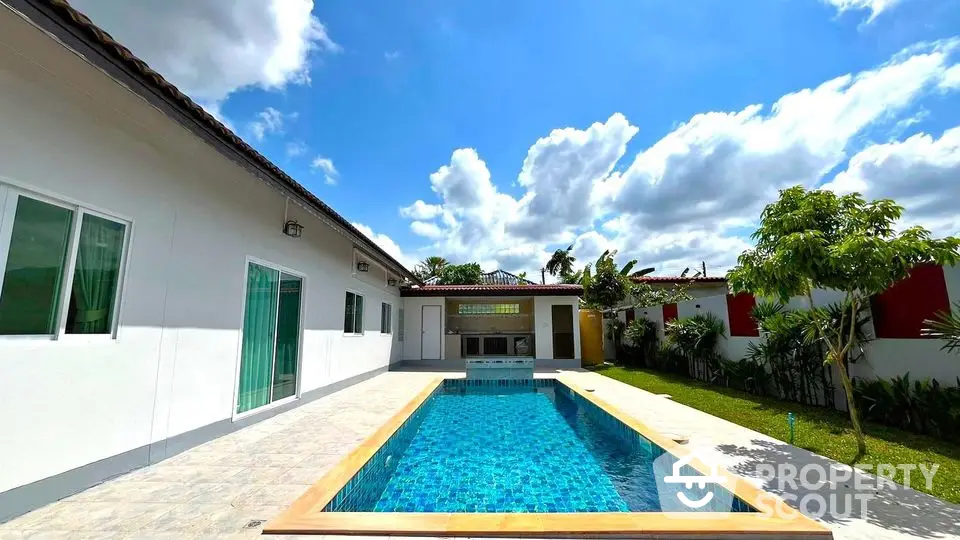 Luxurious villa with private pool and lush garden under a bright blue sky