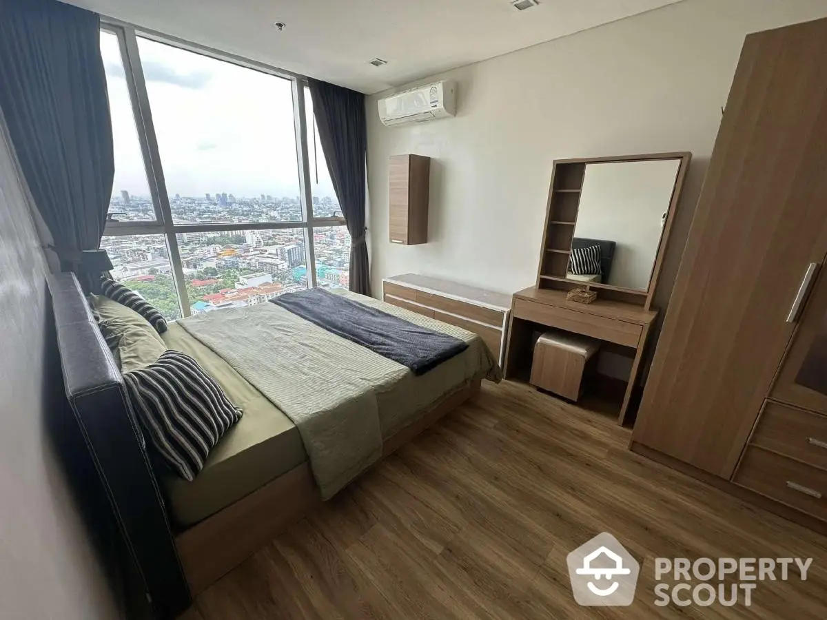 Modern bedroom with city view, featuring wooden furniture and large windows for natural light.