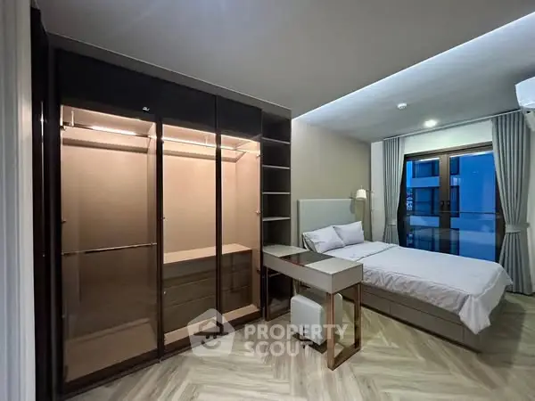 Spacious bedroom with modern wardrobe and cozy bed in elegant apartment.