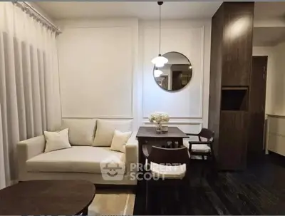 Elegant living room with modern decor, featuring a cozy sofa, stylish dining table, and chic lighting.