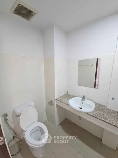 Modern bathroom with sleek fixtures and granite countertop in a contemporary apartment.