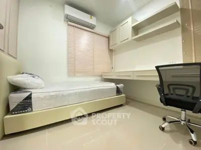 Modern bedroom with single bed, built-in desk, and ergonomic chair in a minimalist design.