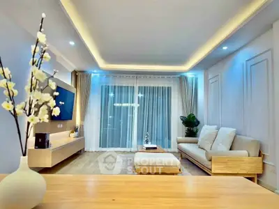 Modern living room with elegant lighting and stylish furniture, featuring a cozy sofa and large window view.