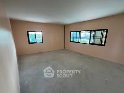 Spacious empty room with large windows and natural light