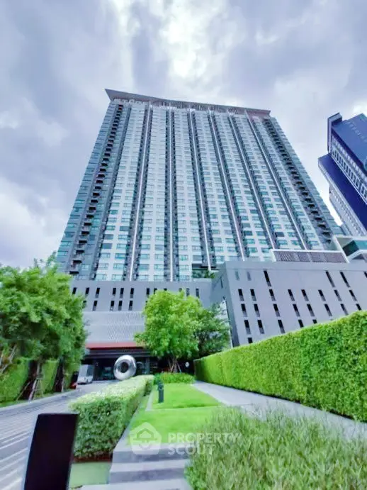 Stunning high-rise building with lush green landscaping and modern architecture.