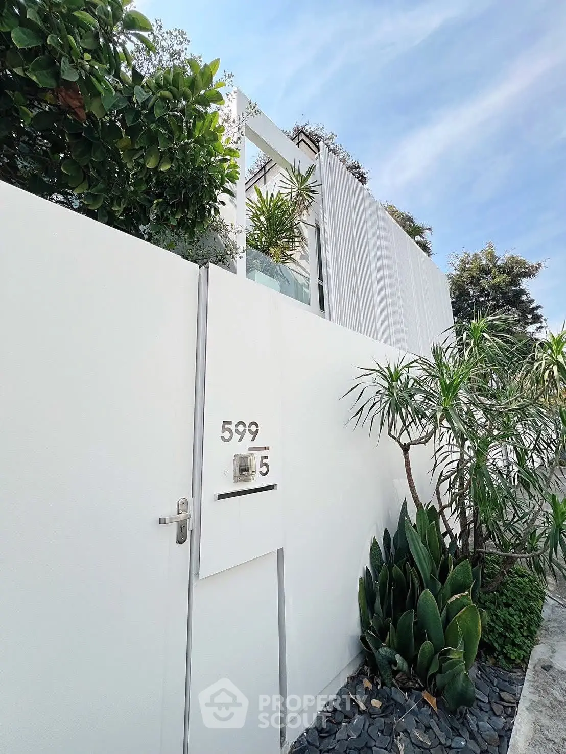 Modern white exterior with lush greenery and sleek design