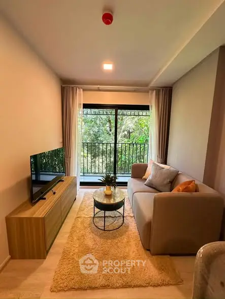 Cozy living room with modern decor and large window overlooking greenery, perfect for relaxation.