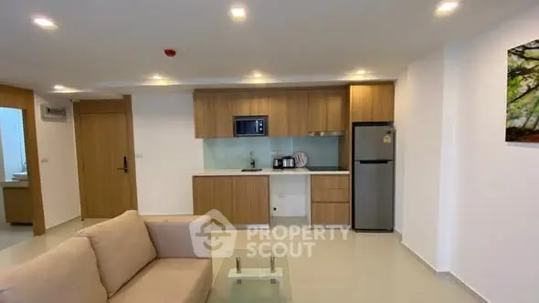 Modern living room with open kitchen and sleek appliances in a stylish apartment.