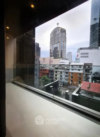 Stunning cityscape view from modern apartment balcony with glass railing.
