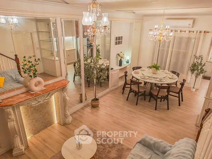 Elegant living and dining area with chandeliers and stylish decor