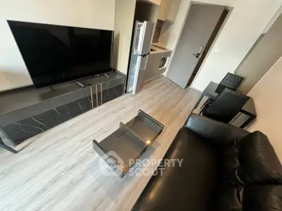 Modern living room with sleek furniture and open kitchen layout in a stylish apartment.