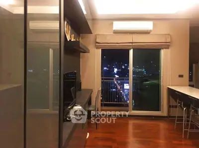 Modern living room with city view, featuring sleek design and hardwood floors.