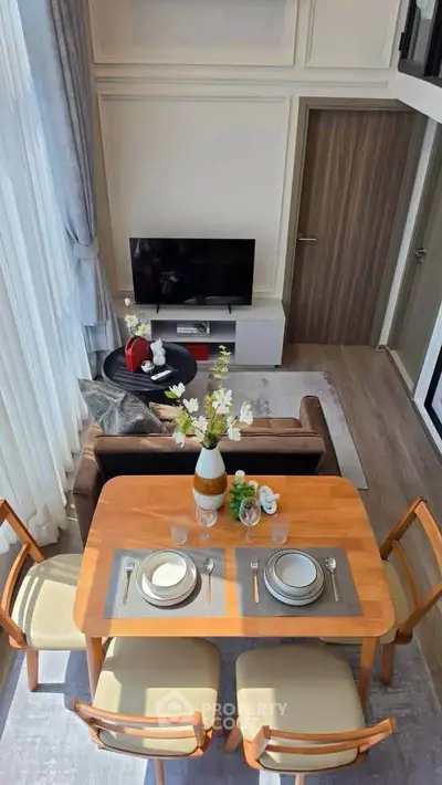 Modern living room with dining area, stylish furniture, and natural light in a cozy apartment.
