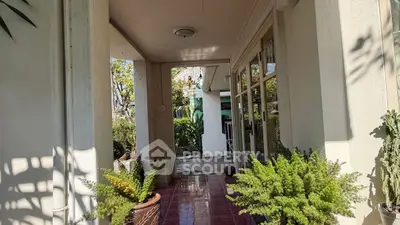 Charming entrance with lush greenery and elegant tiled flooring