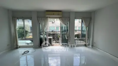 Spacious living room with large windows and city view, perfect for urban living.