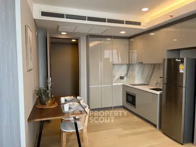 Modern kitchen with sleek cabinetry, integrated appliances, and cozy dining area in stylish apartment.