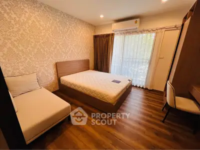 Spacious bedroom with elegant wallpaper and wooden flooring