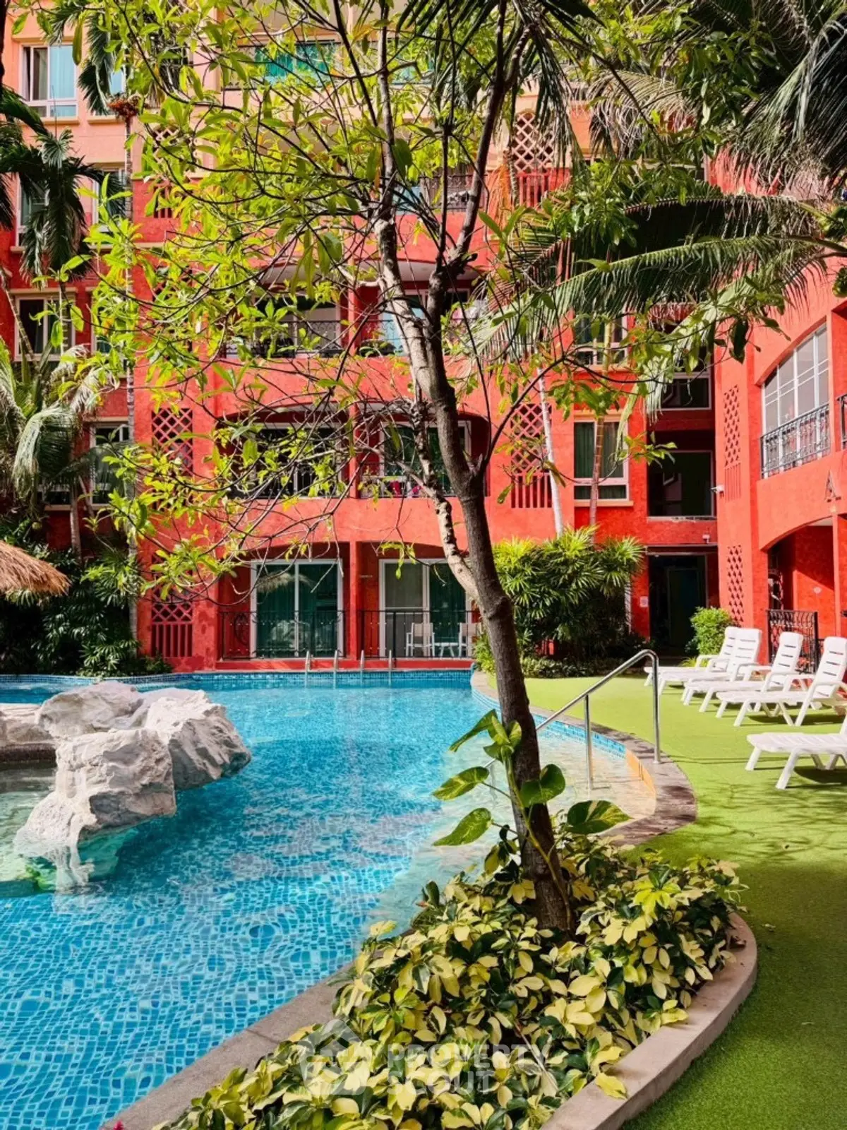 Stunning poolside view with lush greenery and vibrant building facade.