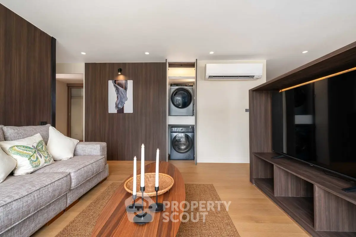 Modern living room with stylish decor and in-unit laundry appliances