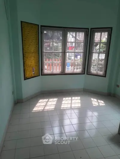 Bright room with large windows and tiled floor, perfect for a cozy living space.