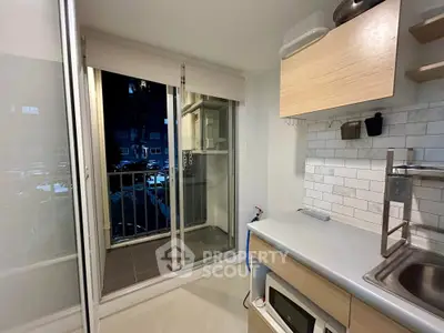 Modern kitchen with balcony access and sleek cabinetry