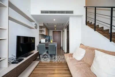 Modern living room with open kitchen and stylish staircase in a contemporary apartment.
