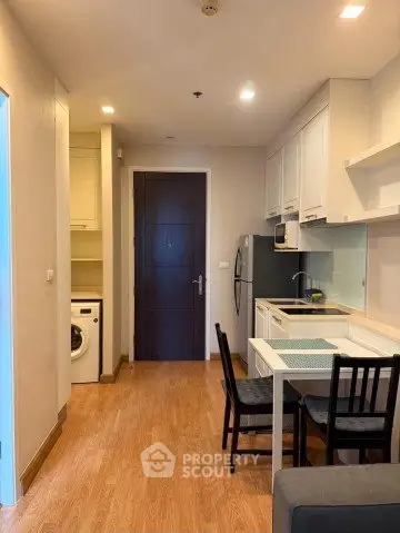 Modern kitchen with dining area and washing machine in compact apartment