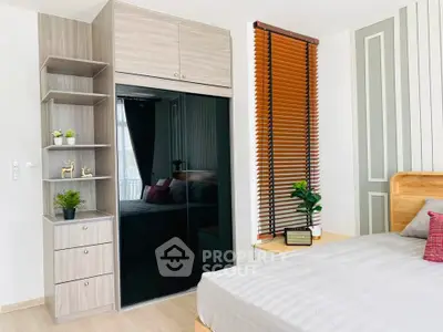 Modern bedroom with sleek wardrobe and stylish decor, featuring natural light and contemporary design.