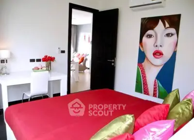 Stylish bedroom with vibrant red bedding and modern art decor