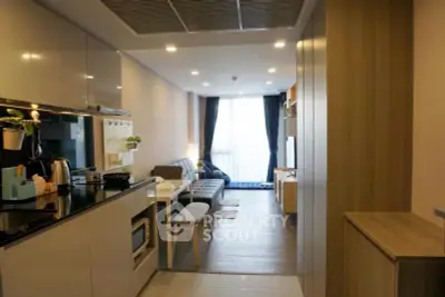 Modern open-layout living room with sleek kitchen and cozy seating area, perfect for urban living.
