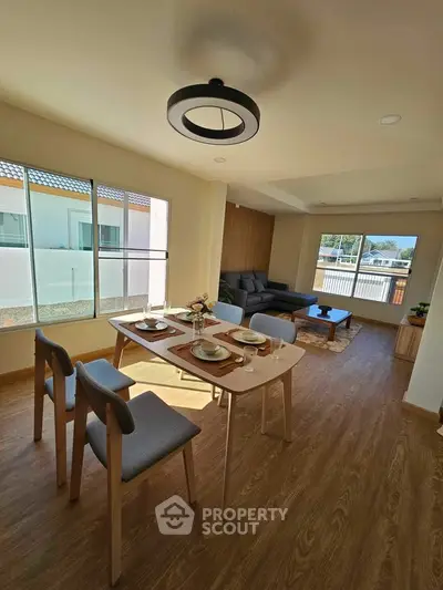 Spacious living room with modern dining area and large windows for natural light.