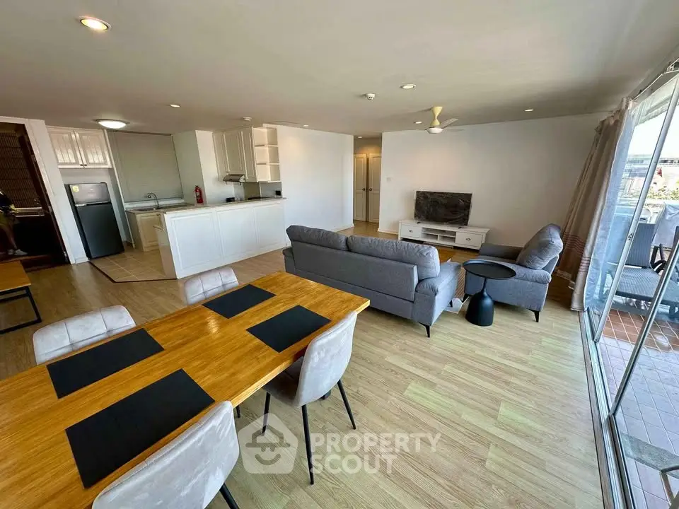 Spacious open-plan living room with modern furniture and large windows offering natural light.