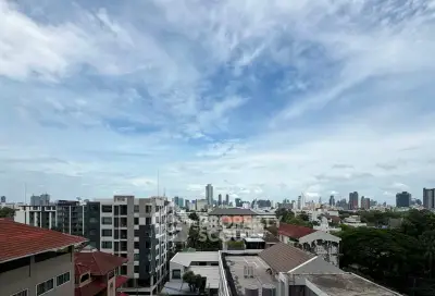 Stunning cityscape view from a high-rise building showcasing urban skyline and lush greenery.
