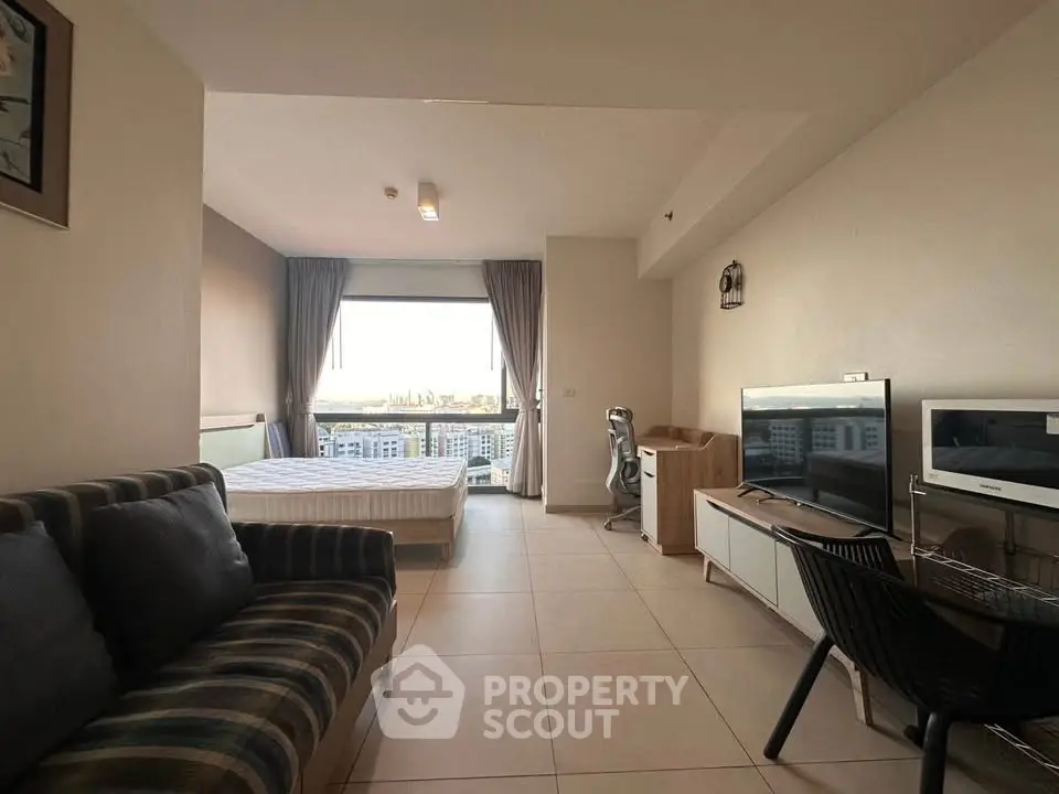 Modern studio apartment with city view, featuring cozy living area and stylish furnishings.