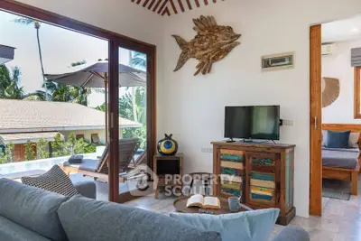 Charming living room with tropical decor and outdoor view, perfect for relaxation.