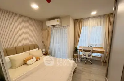 Cozy bedroom with modern decor, featuring a comfortable bed and a study area by the window.