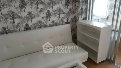 Chic living room with modern white sofa and stylish tree-patterned wallpaper.