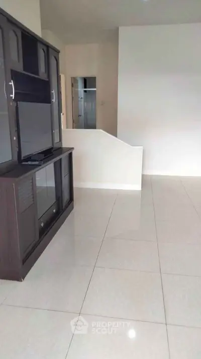 Spacious living room with sleek tile flooring and modern TV cabinet.
