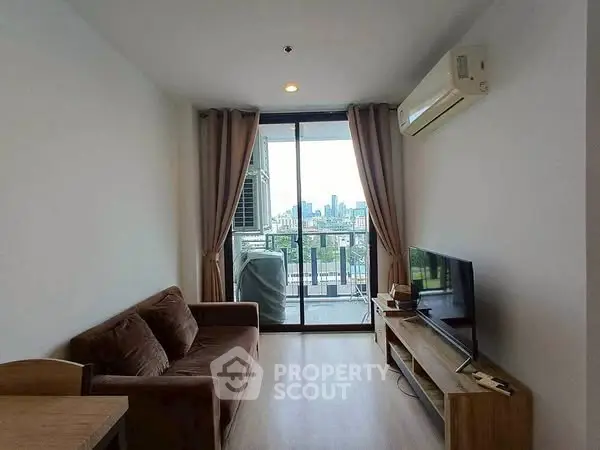 Modern living room with city view, featuring cozy sofa and sleek TV setup.