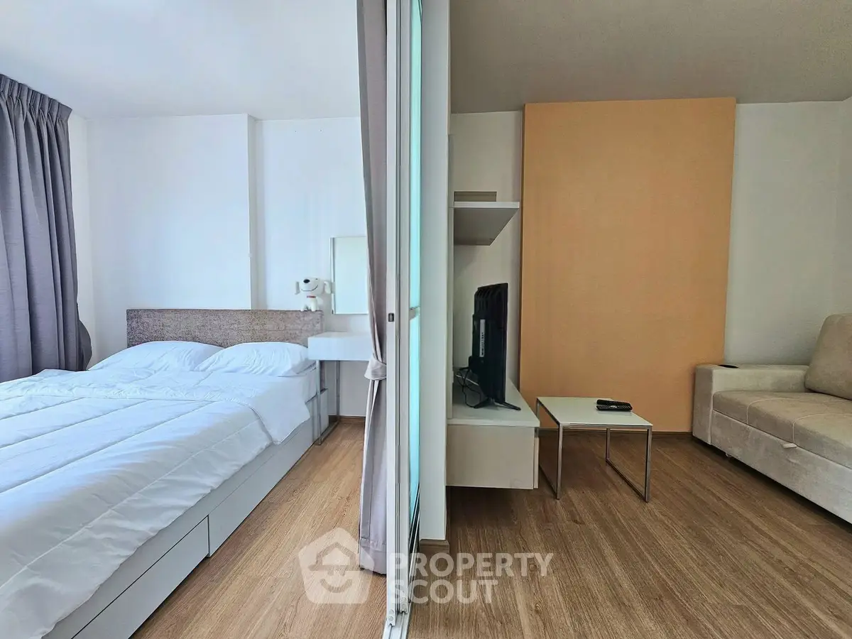 Modern studio apartment with cozy living area and comfortable bed, featuring stylish decor and natural light.
