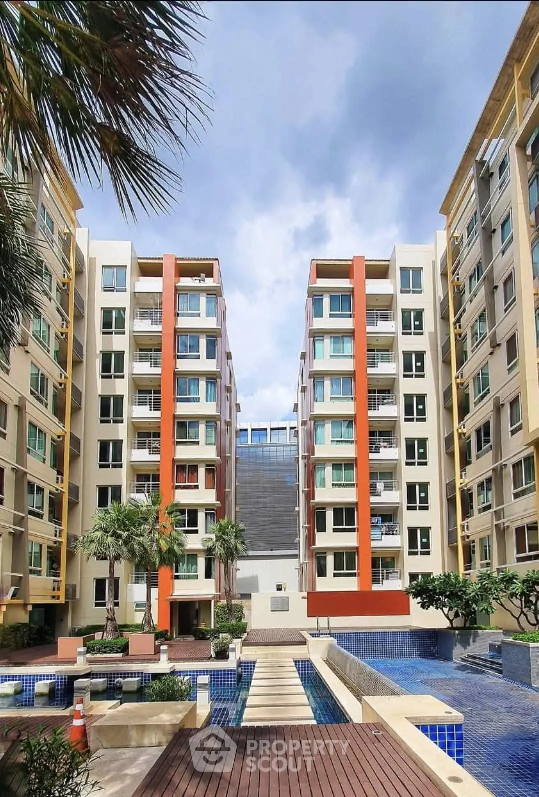 Modern apartment complex with pool and landscaped courtyard, ideal urban living.