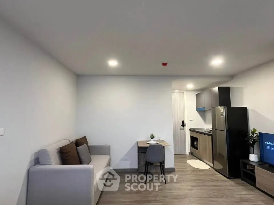 Modern open-plan living room with compact kitchen and cozy seating area