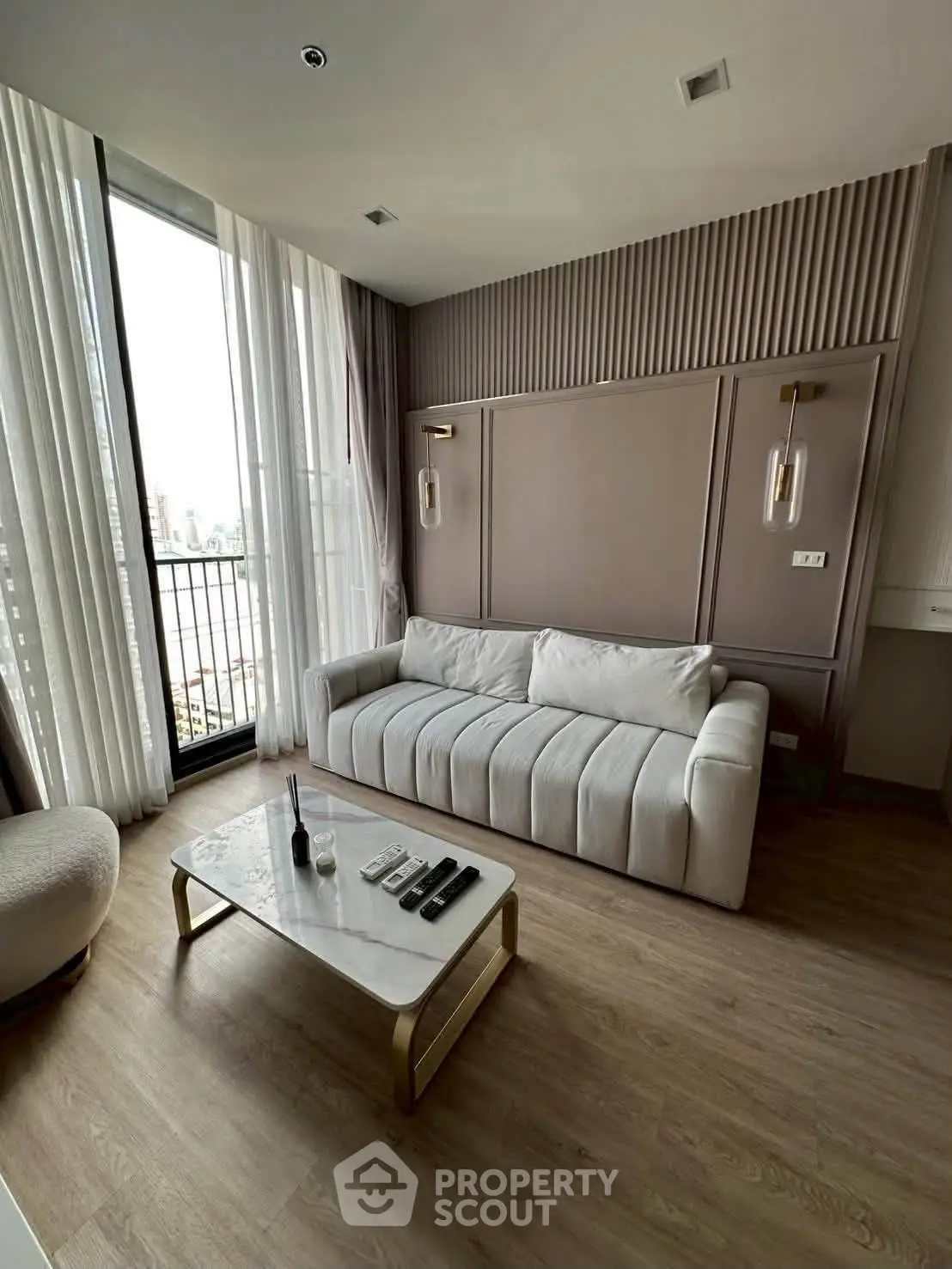 Modern living room with elegant decor and large windows offering city views