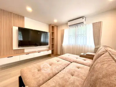 Spacious living room with modern decor and large TV, perfect for relaxation.