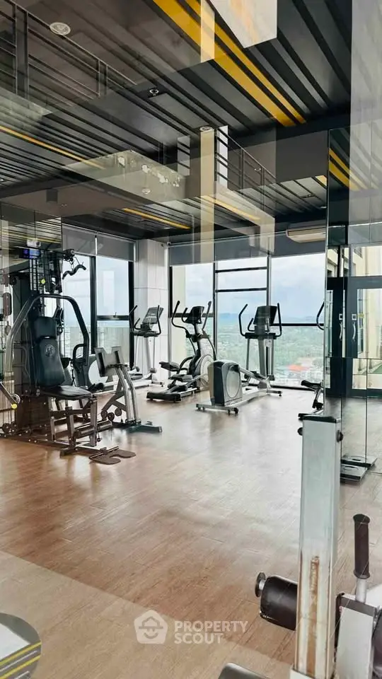 Modern gym with panoramic city views and state-of-the-art fitness equipment.