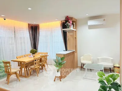 Modern living room with dining area, featuring elegant wooden furniture and bright natural lighting.