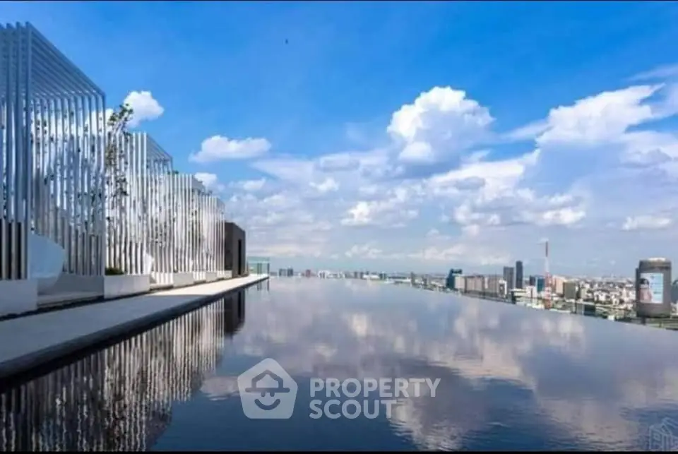 Stunning rooftop infinity pool with panoramic city skyline views under a clear blue sky.