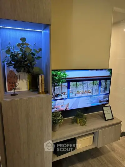 Modern living room with stylish shelving and TV display, featuring elegant decor and ambient lighting.