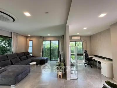Spacious modern living room with garden view and home office setup