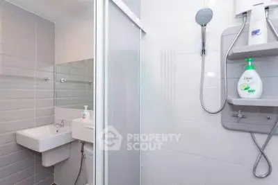 Modern bathroom with shower, sink, and tiled walls in a sleek design.